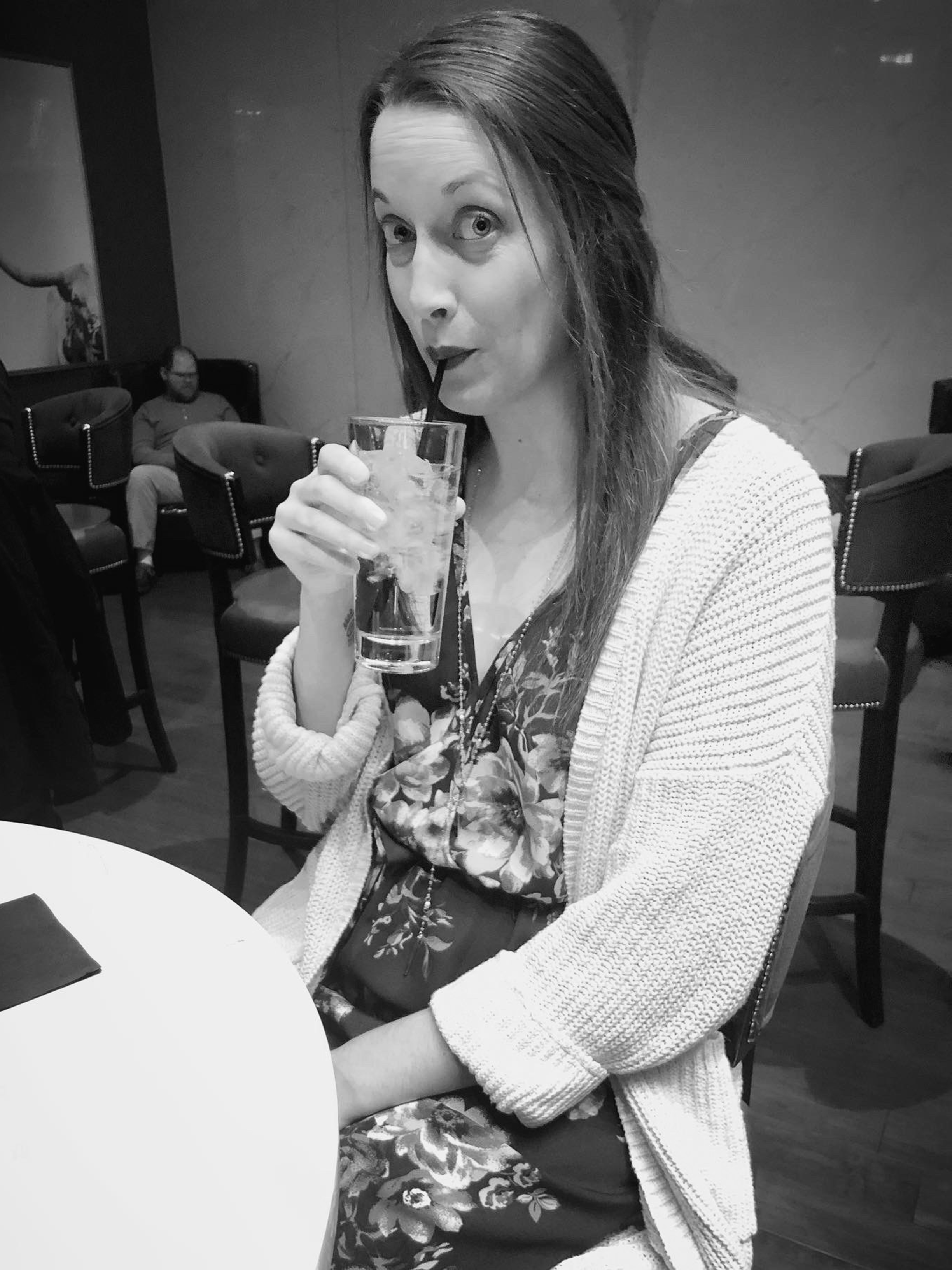 Katy Williams sipping from drink with straw in downtown Indy restaurant